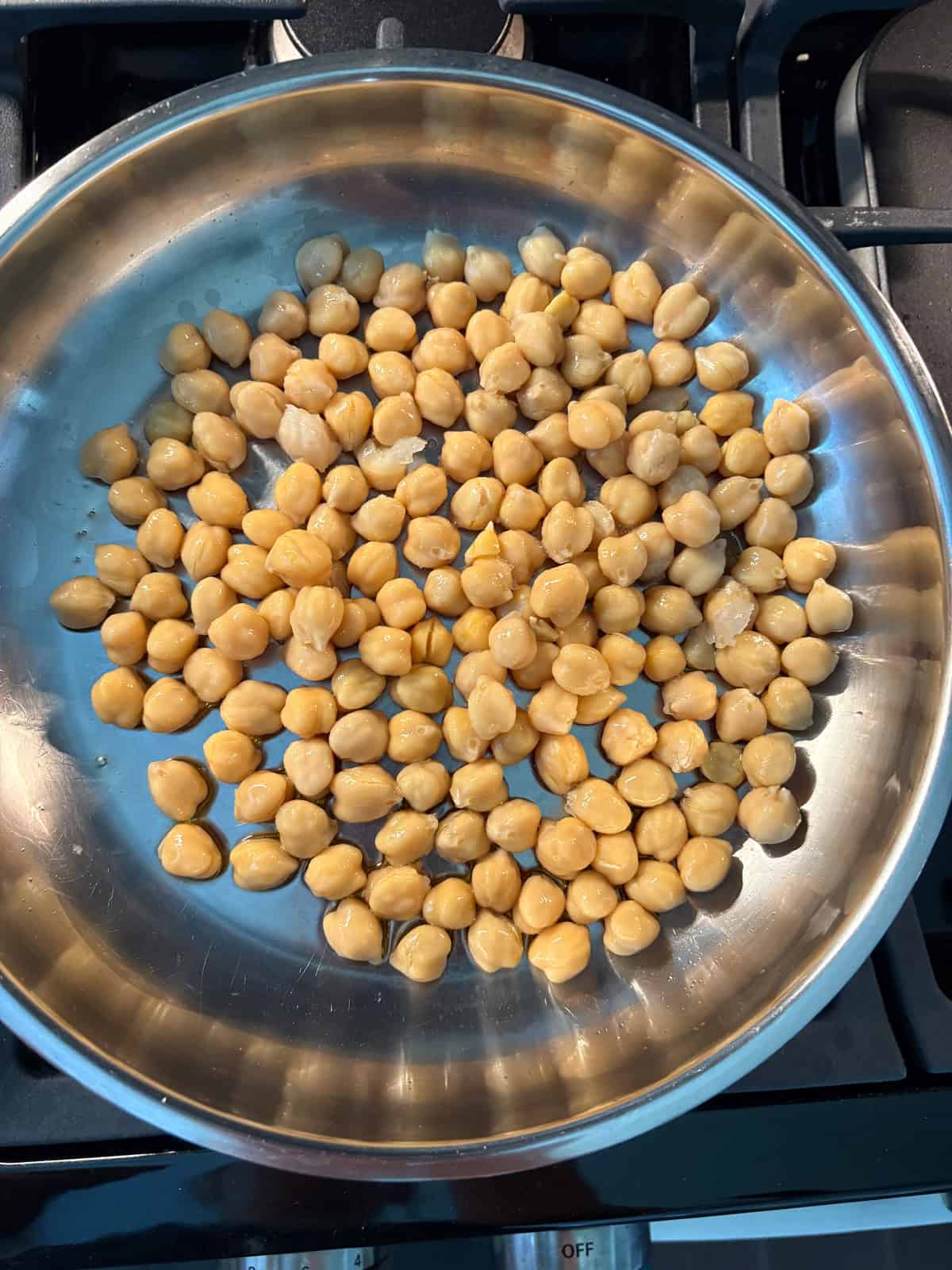 Chickpeas sauteing in a pan.