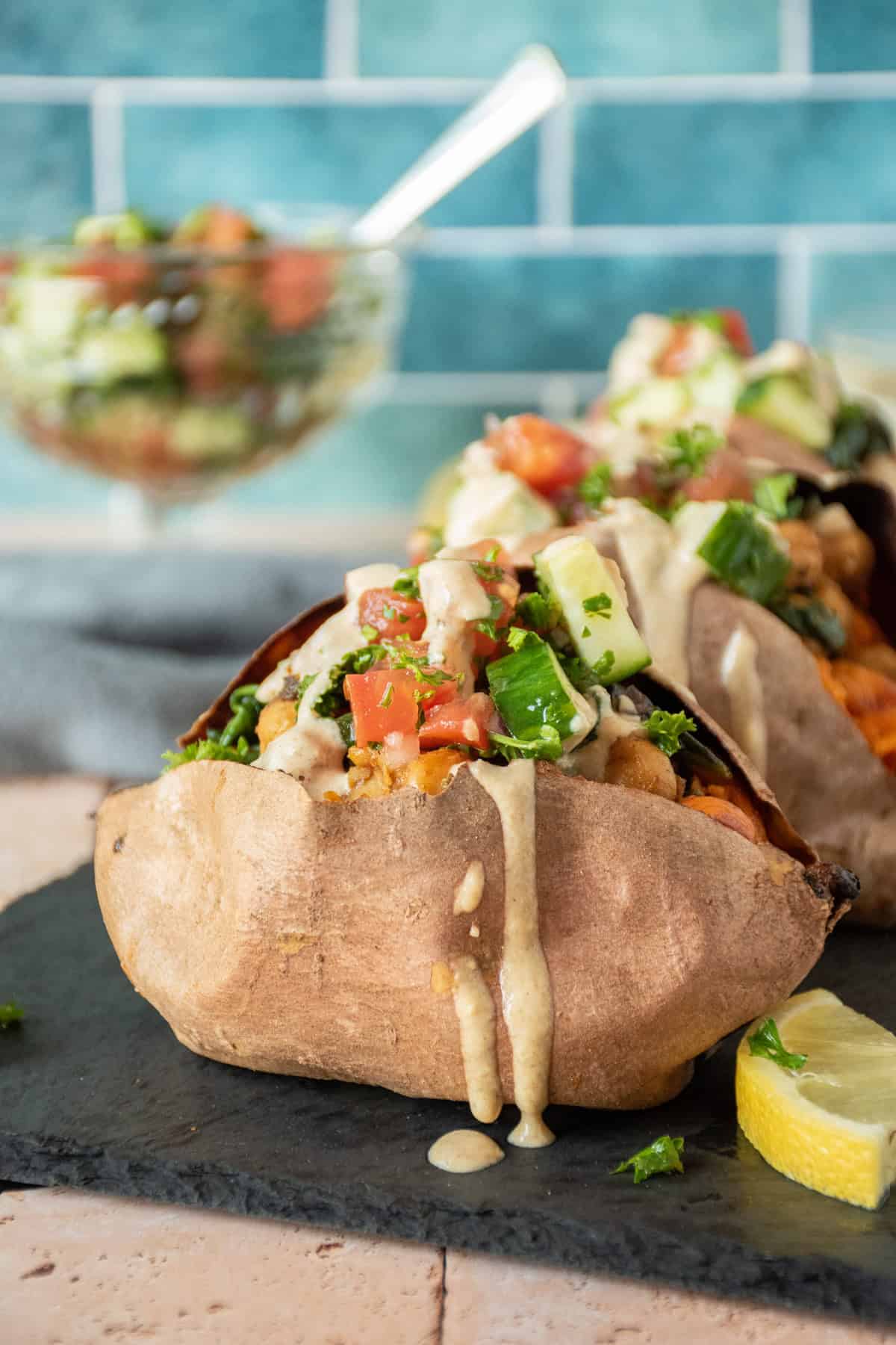Sweet potato, stuffed with chickpeas and cucumber salad, and drizzled with tahini dressing.