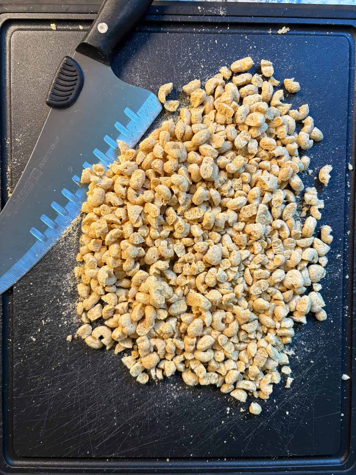 Cereal chopped into small pieces on a cutting board.