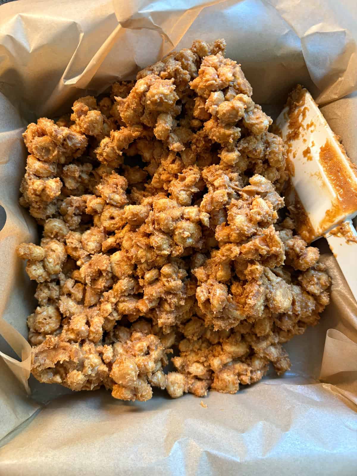 Cereal peanut butter mixture poured into a pan in a pile.