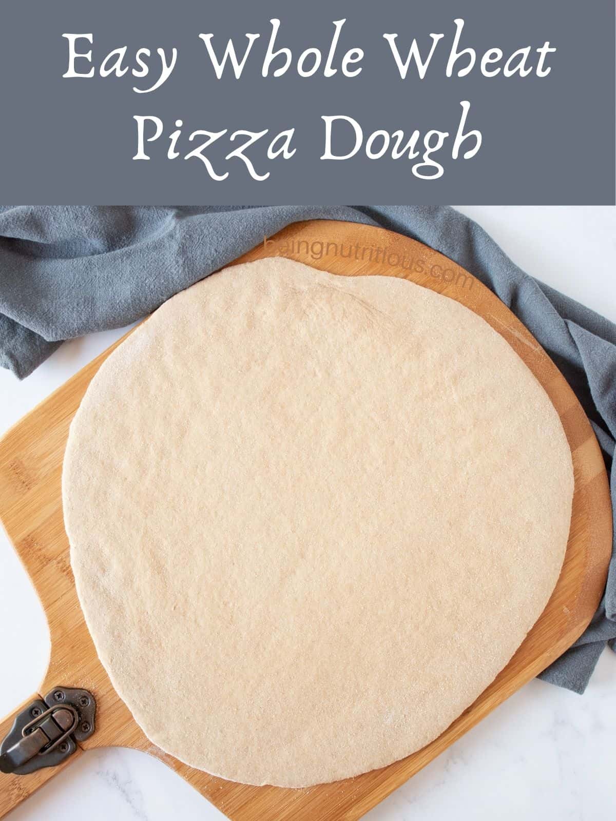 Raw pizza dough, rolled out to a circle, on a pizza peel. Text overlay: Easy Whole Wheat Pizza Dough.