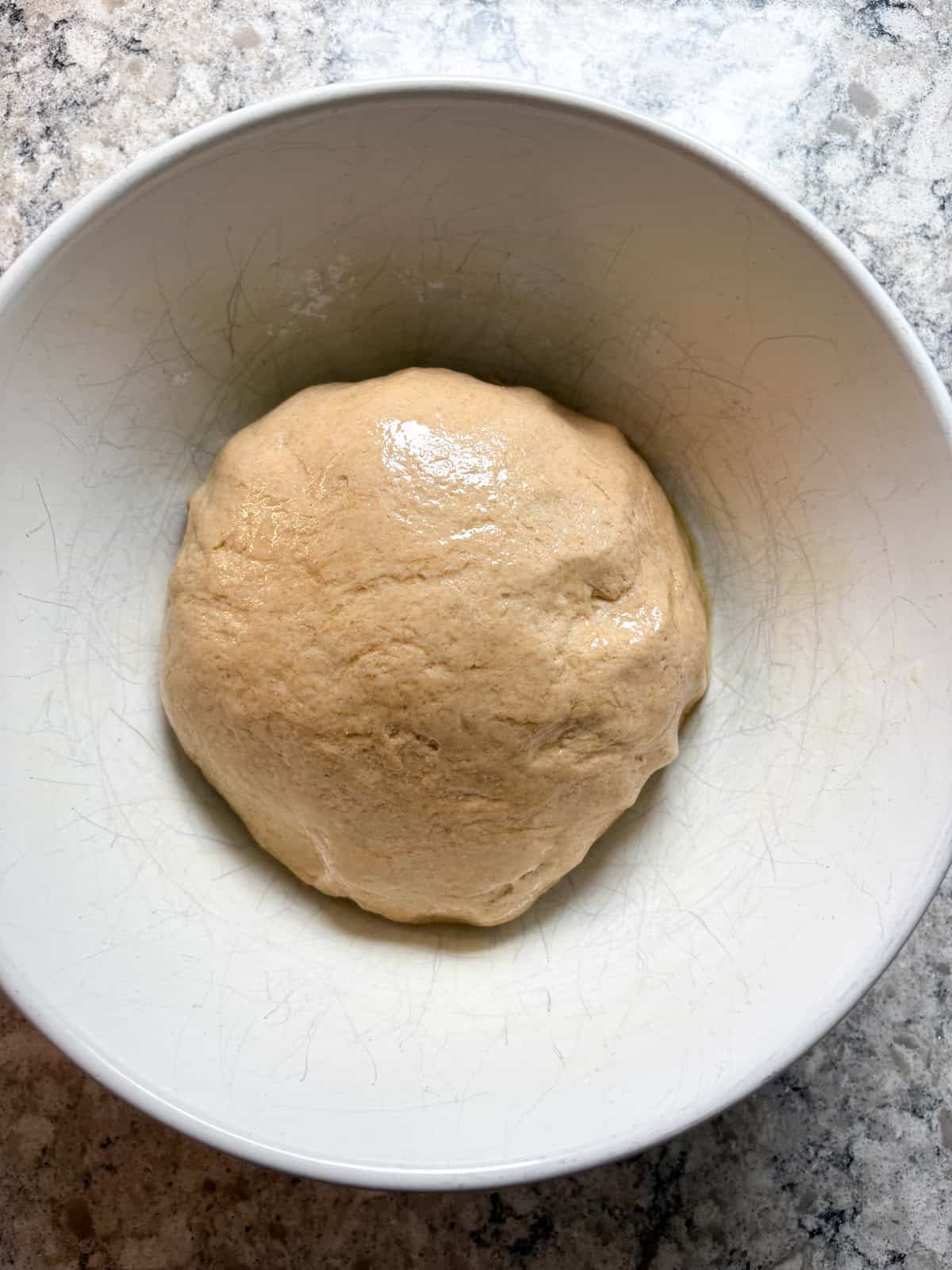 Raw dough in an oiled bowl.