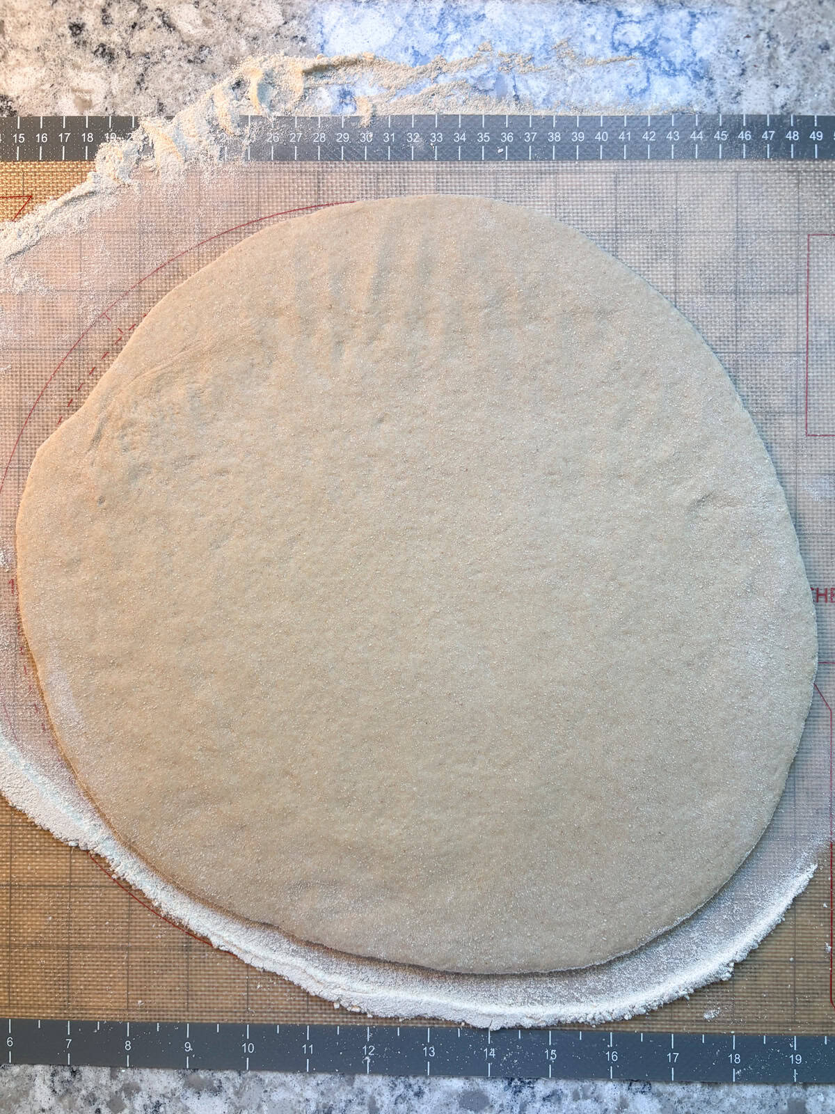 Pizza dough rolled out to about 12 inches in diameter.