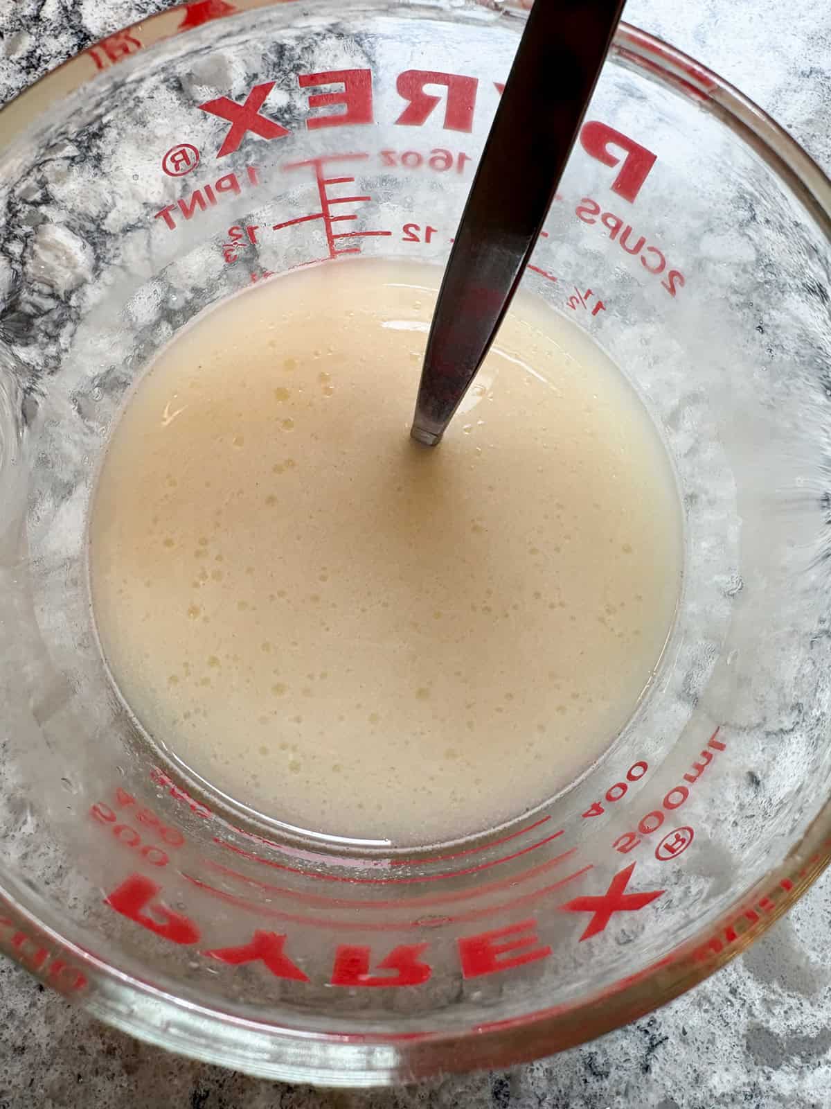 Active dry yeast and maple syrup stirred into warm water.