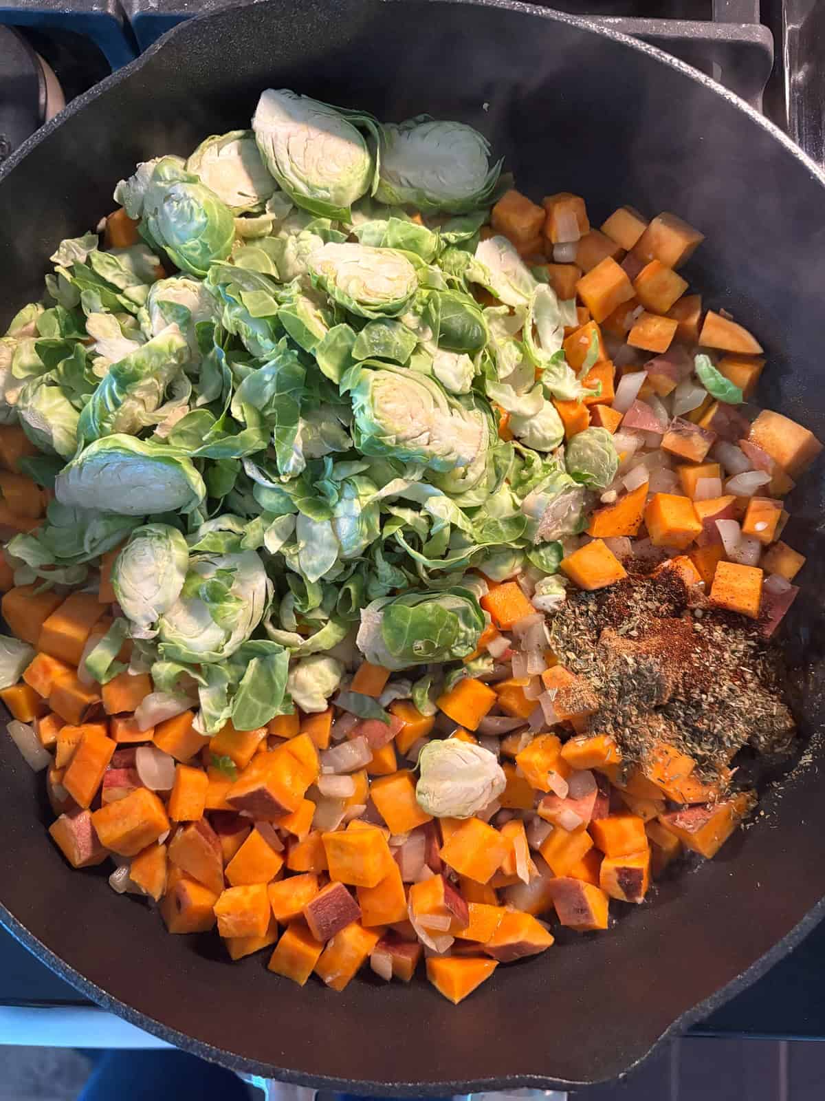 Brussels sprouts, spices, and vinegar added to the sauteing sweet potato mixture.