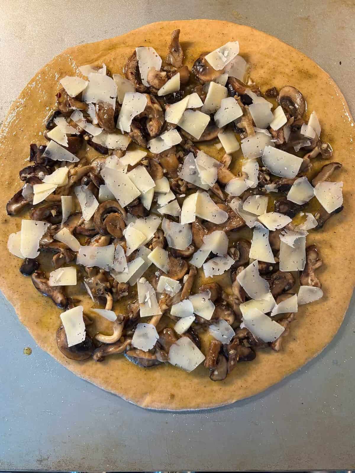 Parmesan cheese added to the pizza.