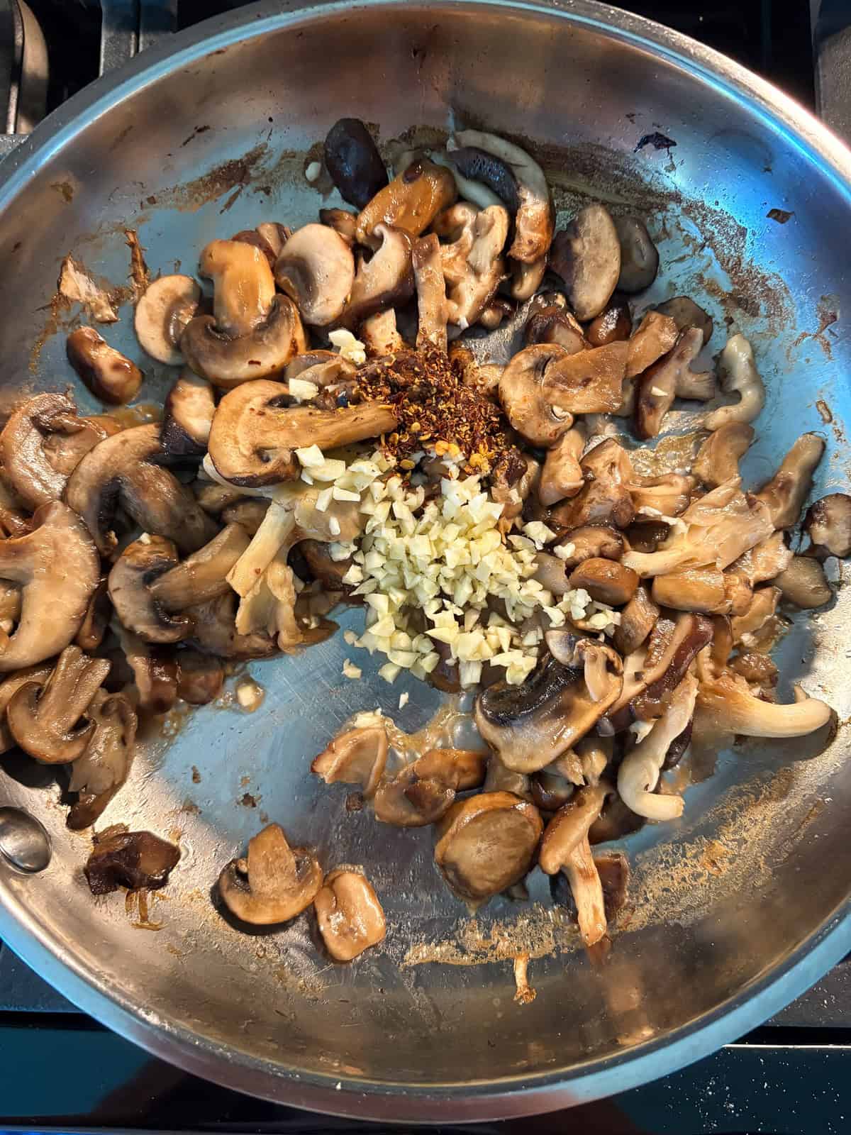 Garlic and red pepper flakes added to the sautéed mushrooms.