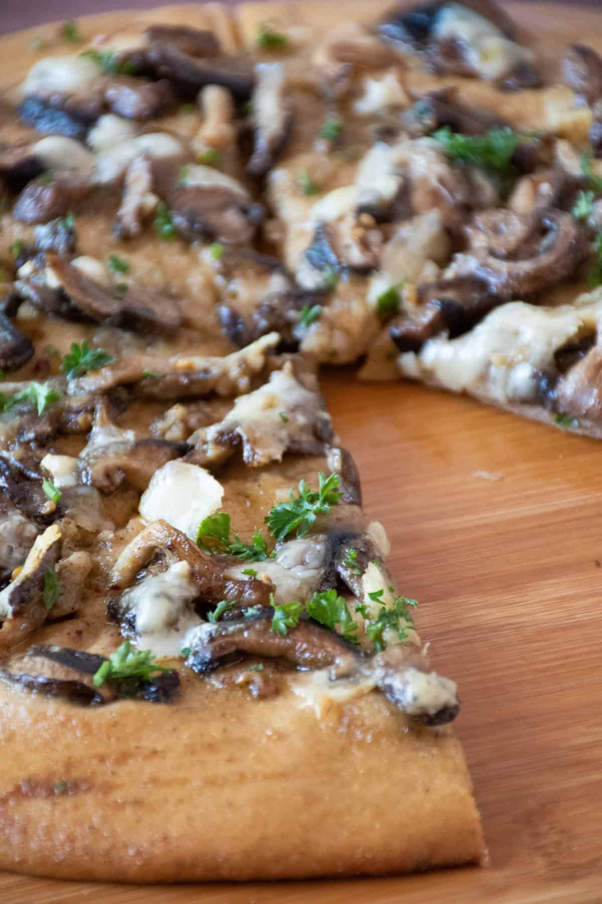 Close up of pizza on a pizza peel, with one slice missing.