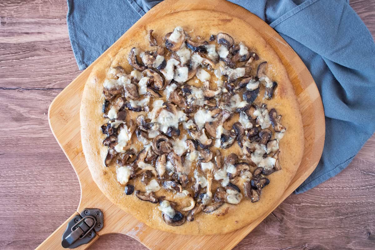 Overhead image of a whole pizza on a pizza peel.