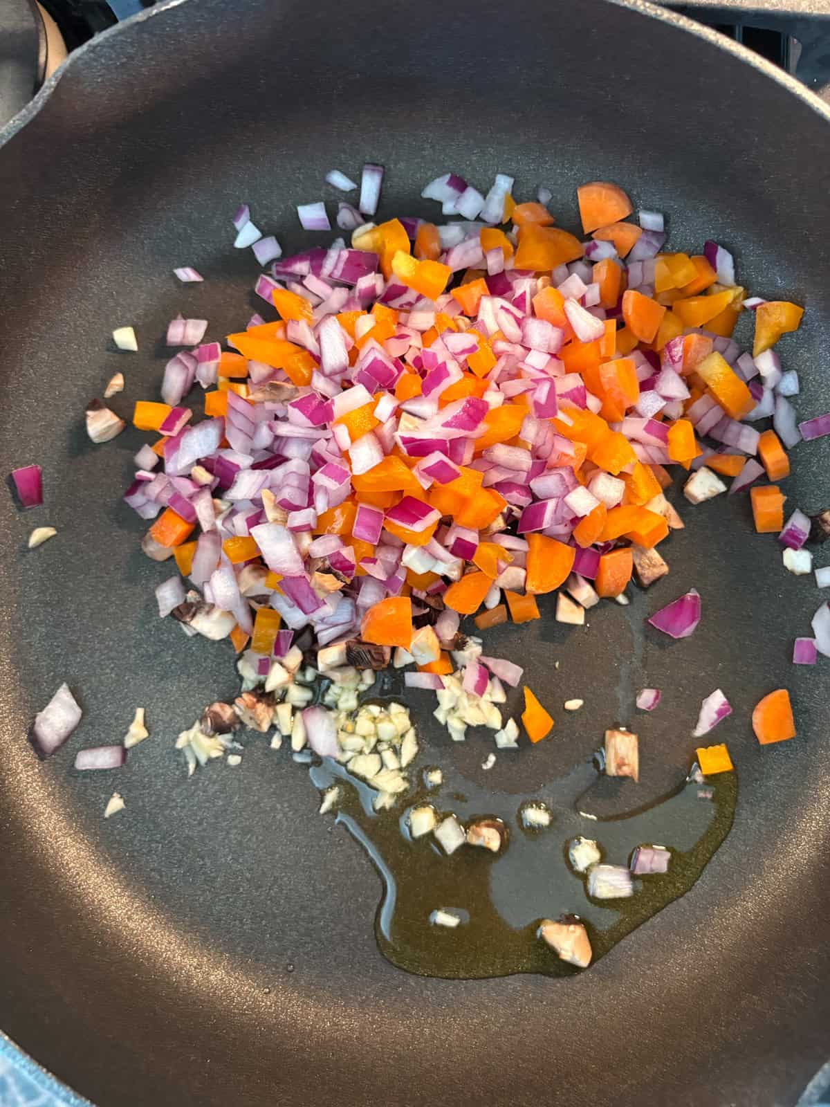 Garlic and chopped veggies sauteing in a pan.