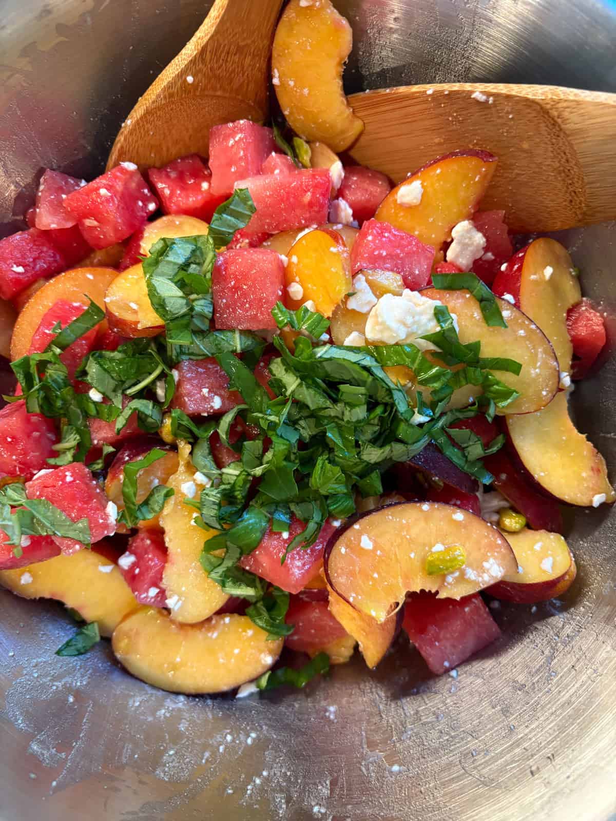 Fruit salad tossed, and chiffonade basil sprinkled on top.
