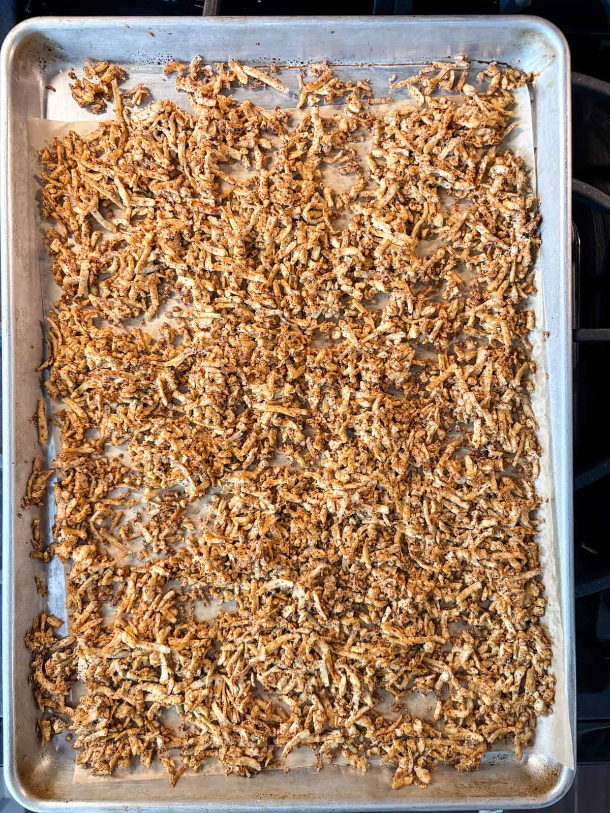 Shredded baked tofu on a baking sheet.