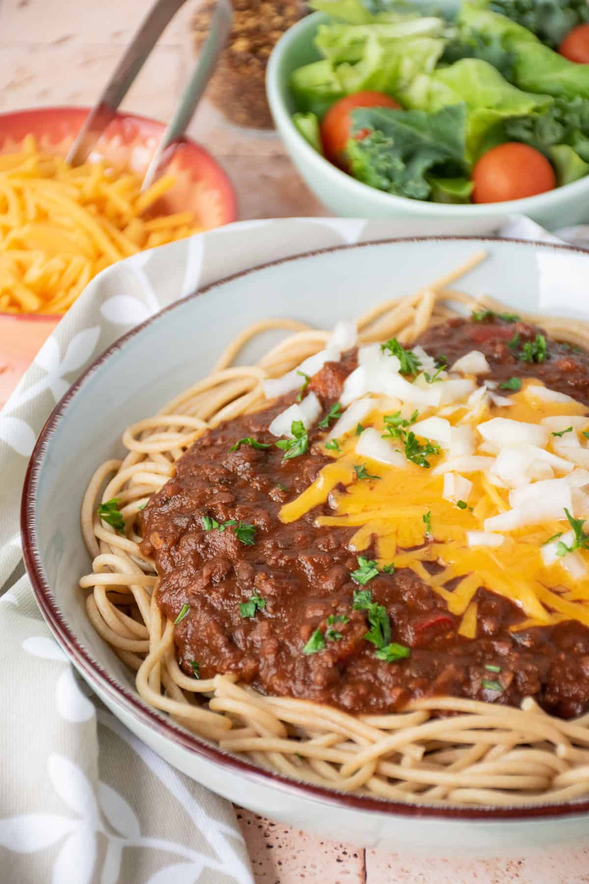 Bowl with spaghetti topped with Cincinnati chili, cheese, and onions.