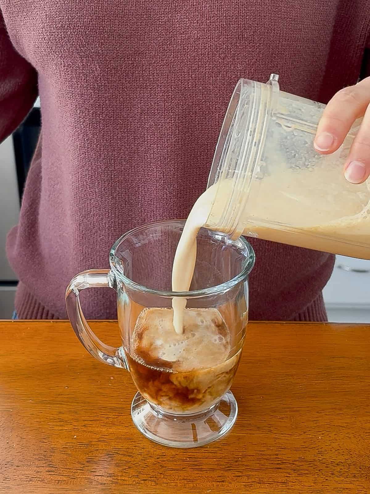 Pouring the blended milk into the espresso.