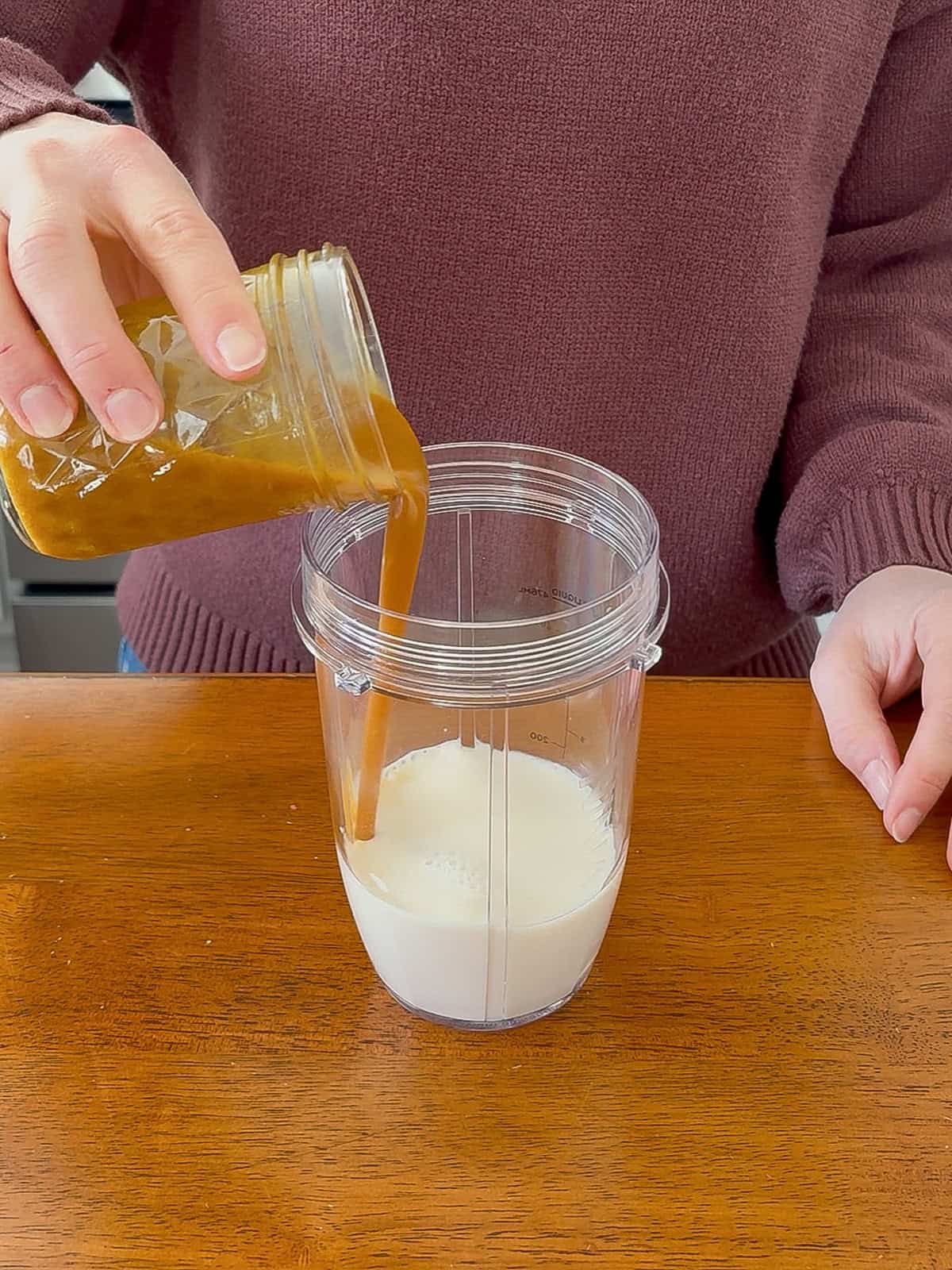 Adding the pumpkin spice syrup to the blender.
