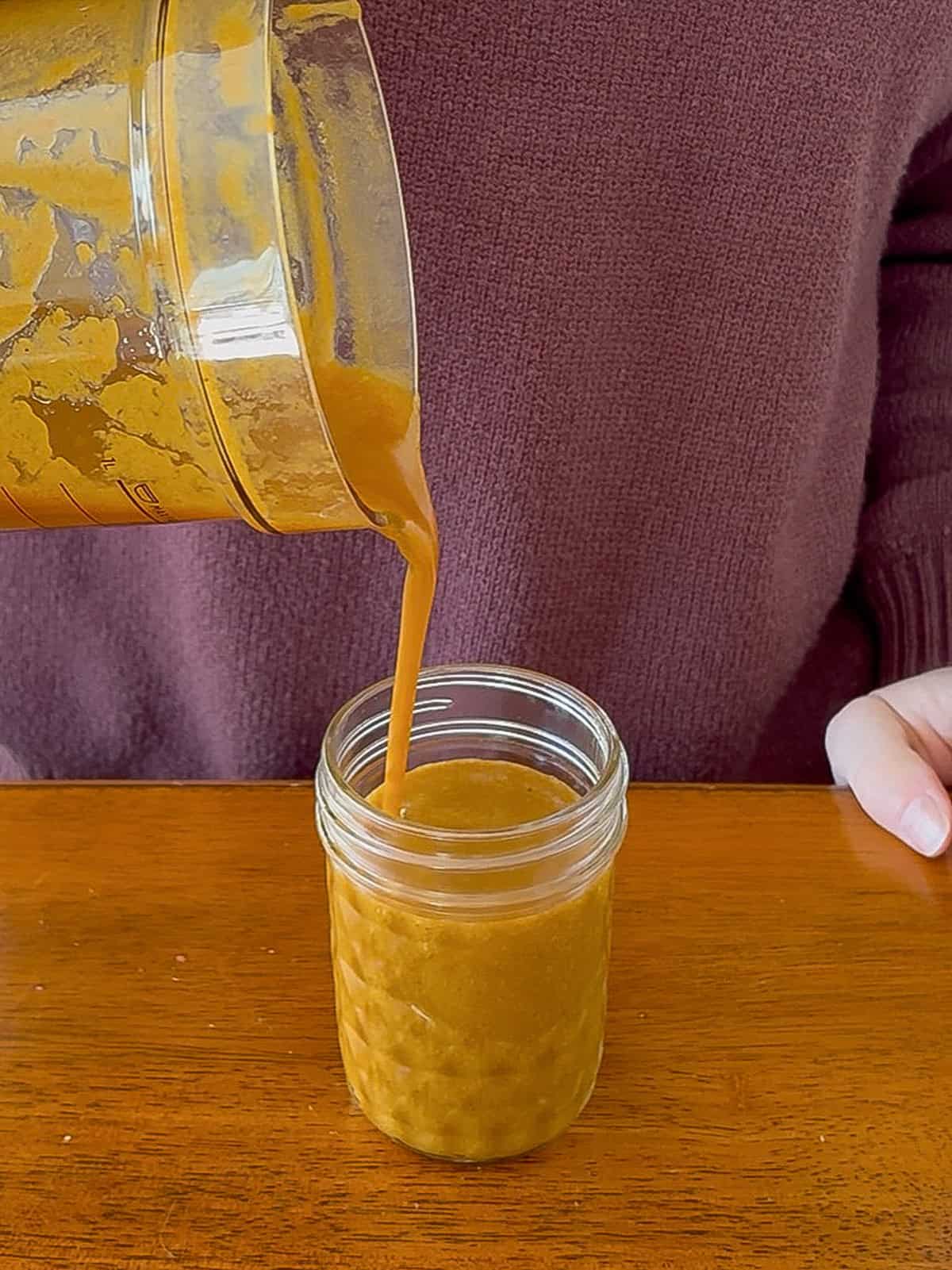 Pouring the pumpkin spice syrup into a jar.