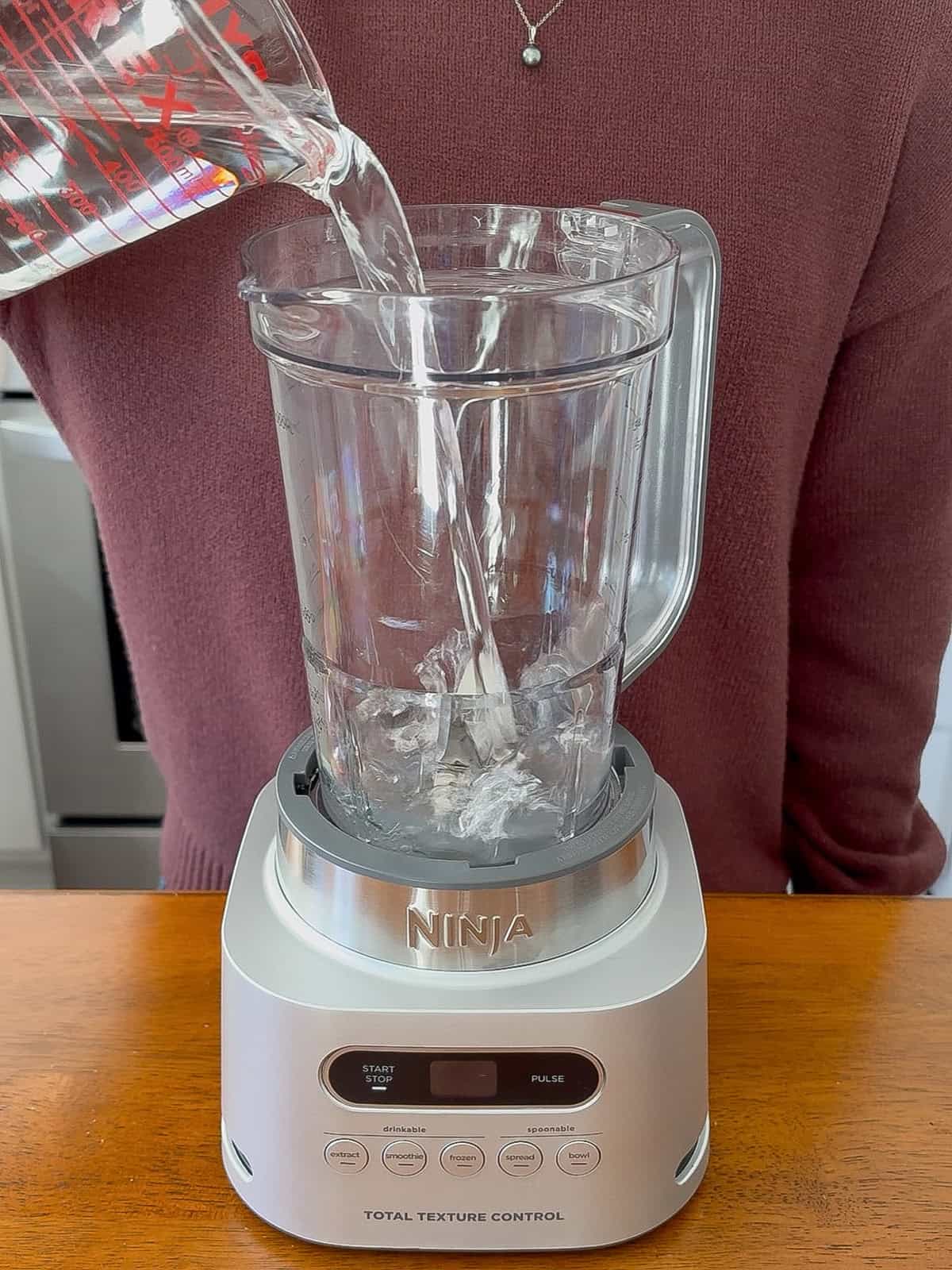 Adding water to the blender.