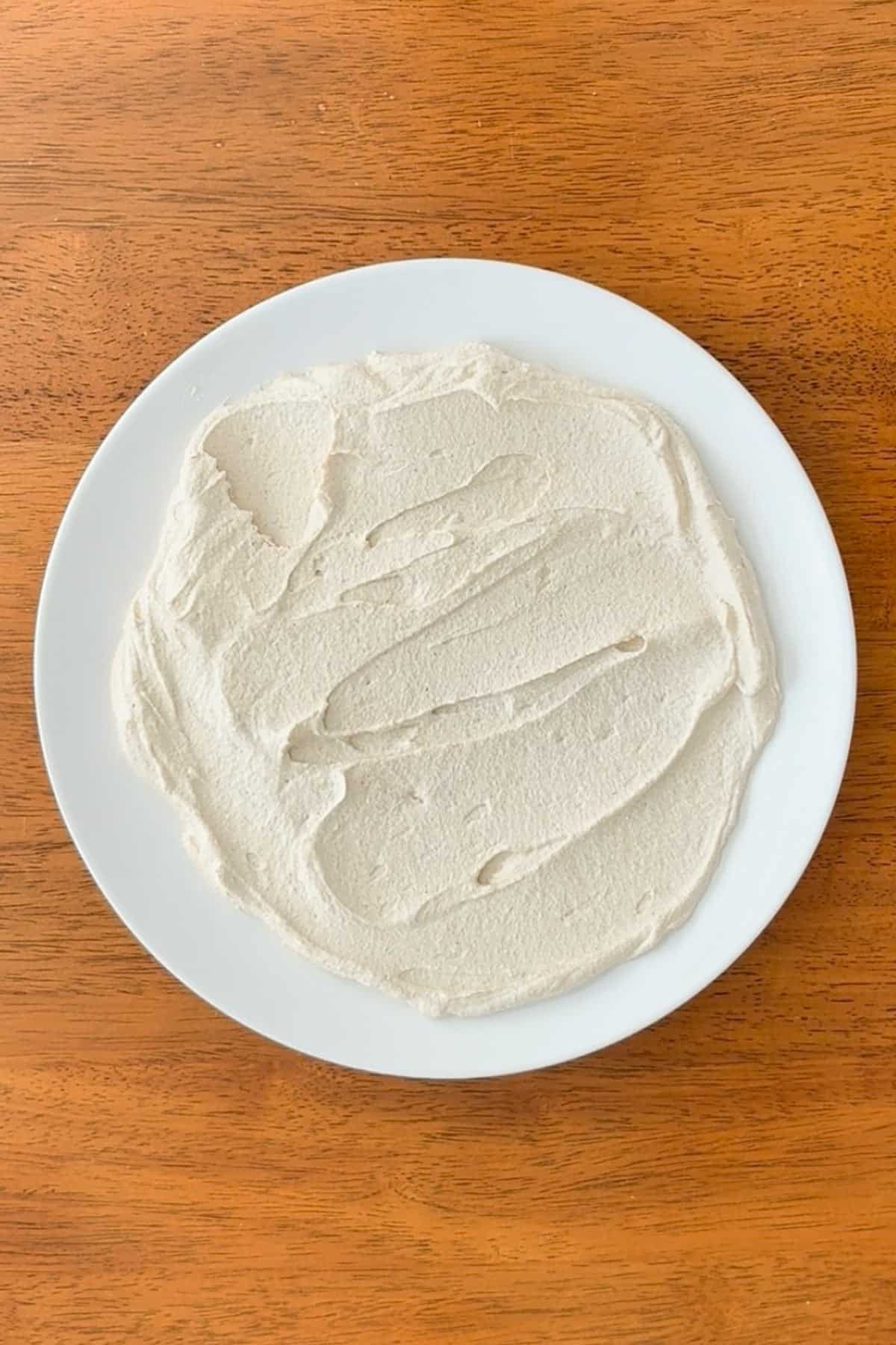 Whipped tofu spread onto a serving plate.