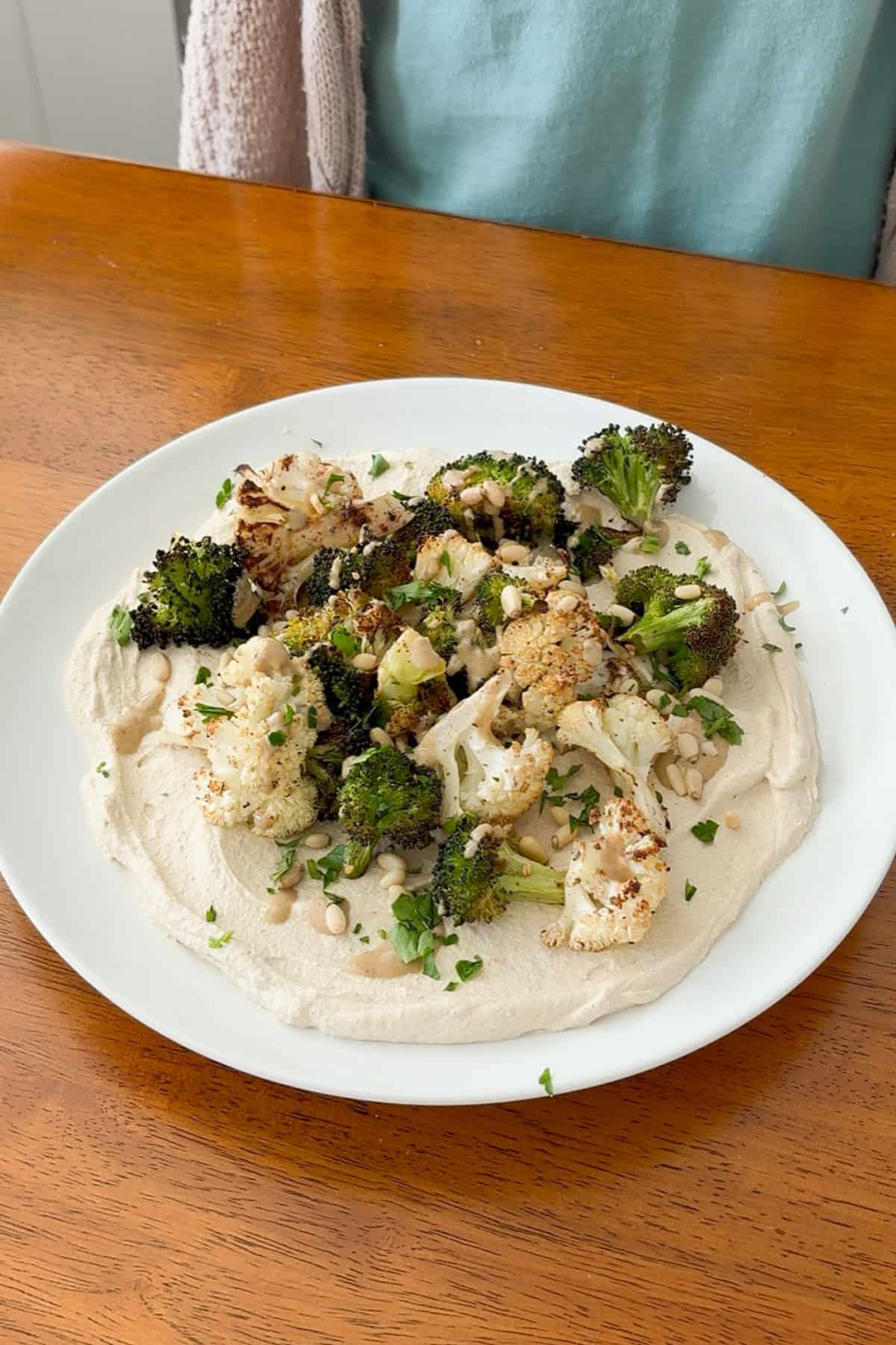 Roasted broccoli and cauliflower over whipped tofu, drizzled with tahini and sprinkled with pine nuts and parsley.