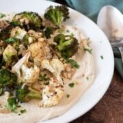 Roasted broccoli and cauliflower on a plate, over whipped tofu.