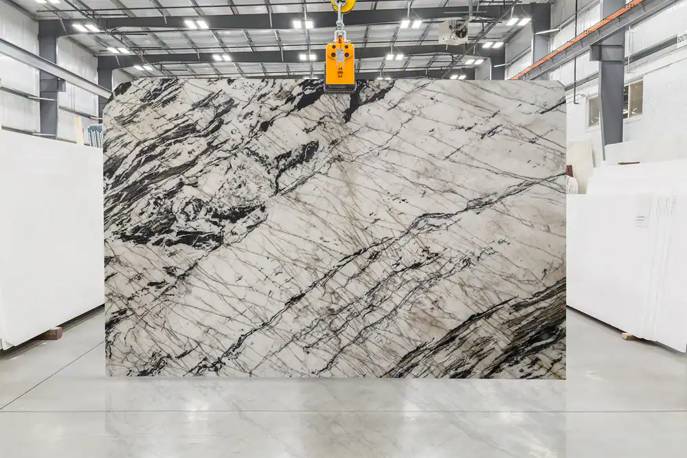 Large marble slab with black and white veining in industrial setting.