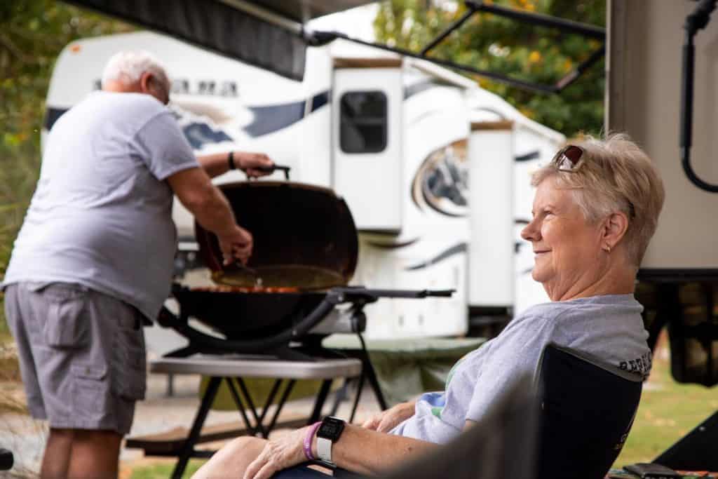 Couple grilling in front of their RV
