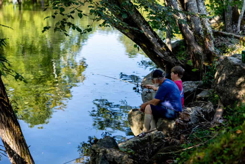 Two children fishing in a pond near the big meadows campground.