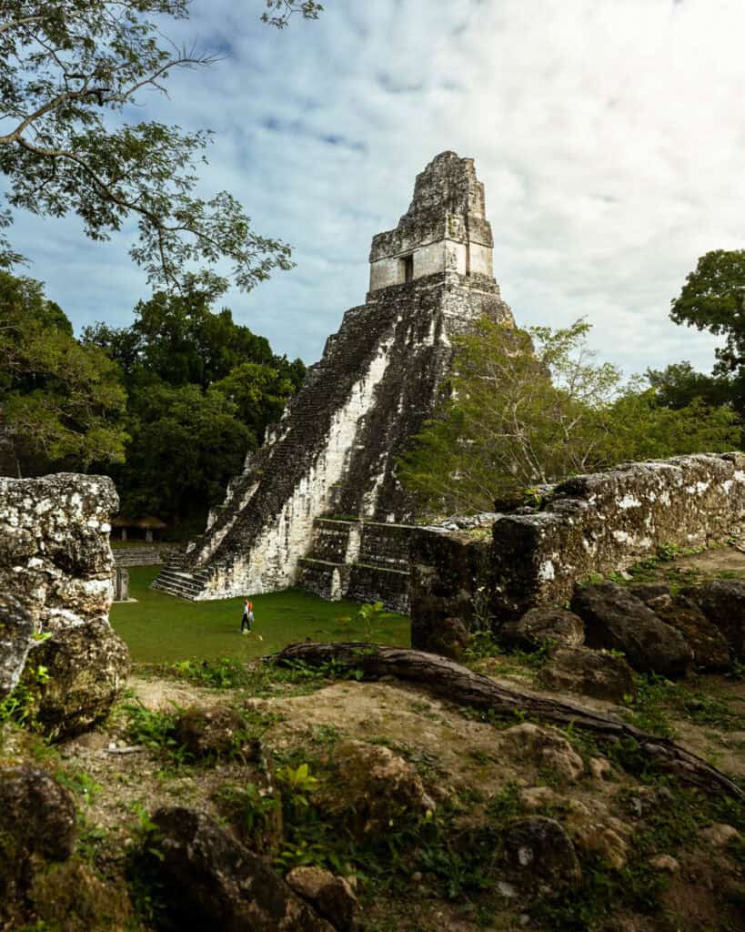 A tourist walking past the Temple of the Jaguar at Tikal, Guatemala