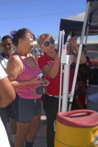 Health promoter checks weight at a health fair. Knowledge is the first step in fighting disease.