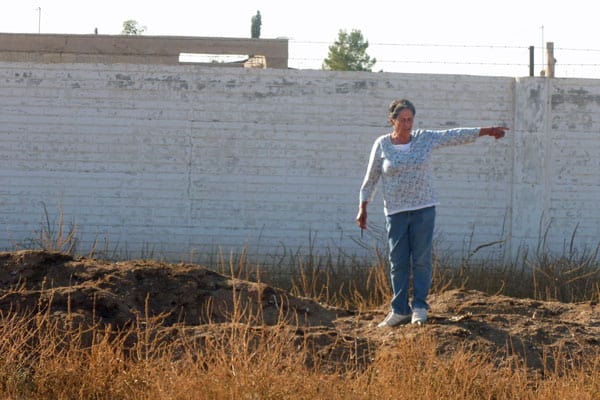 Gardening coordinator Juana Lazoya stands atop a compost pile indicating the span of soil created to enrich the home gardens carved from the desert sands of Puerto Palomas.