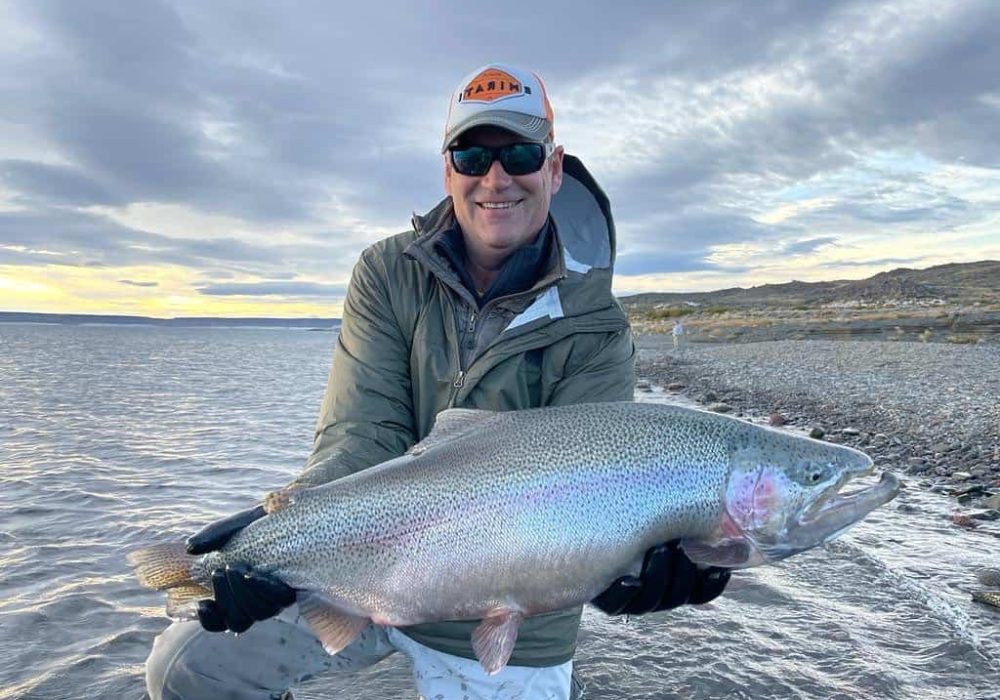 angler holding large rainbow trout caught in jurassic lake