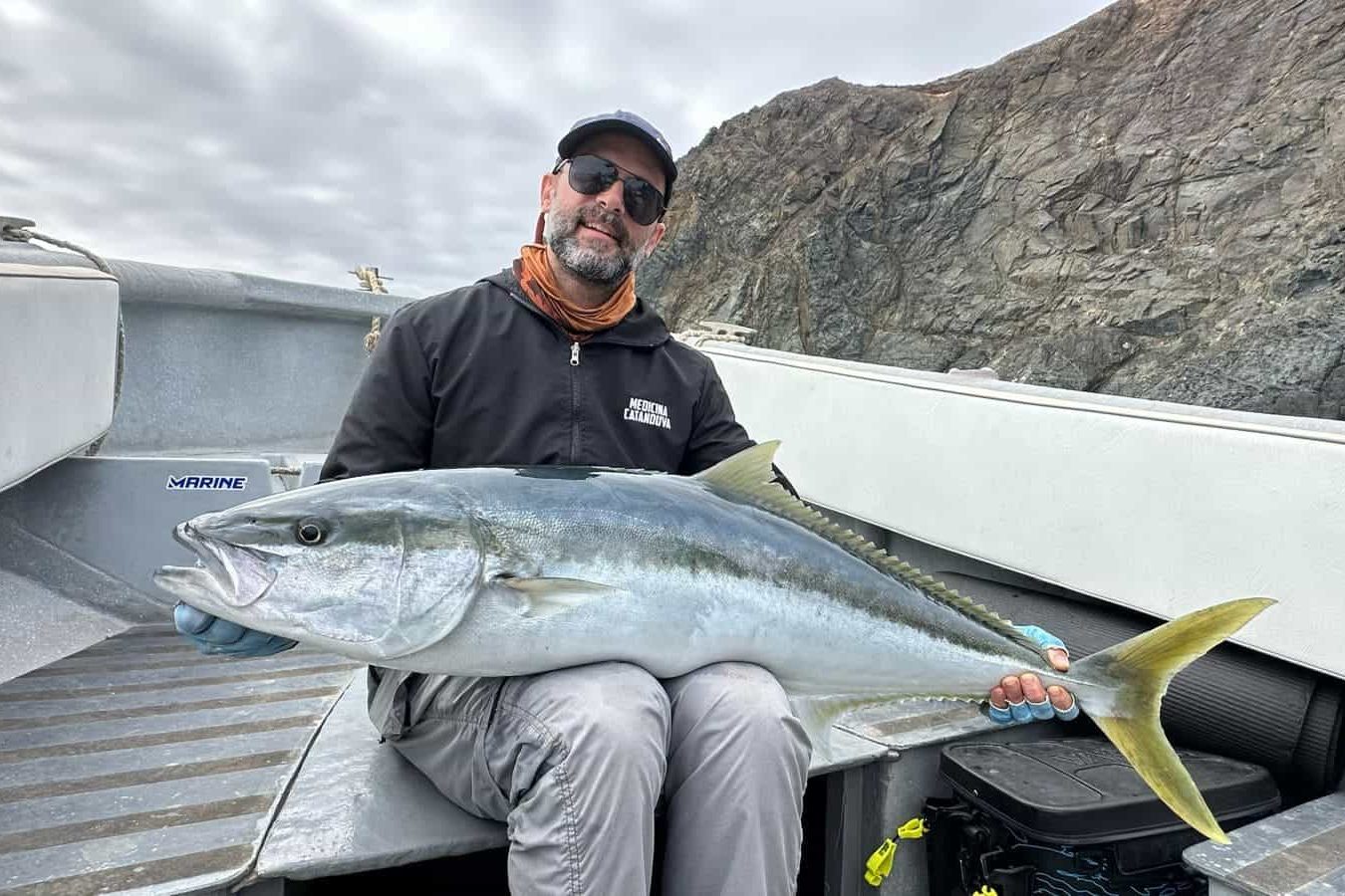 angler posing with large yellowtail kingfish