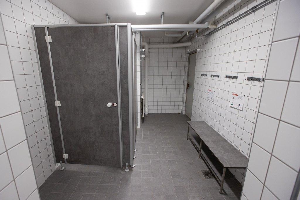 Toalettstol och väggar i offentligt badrum eller omklädningsrum.