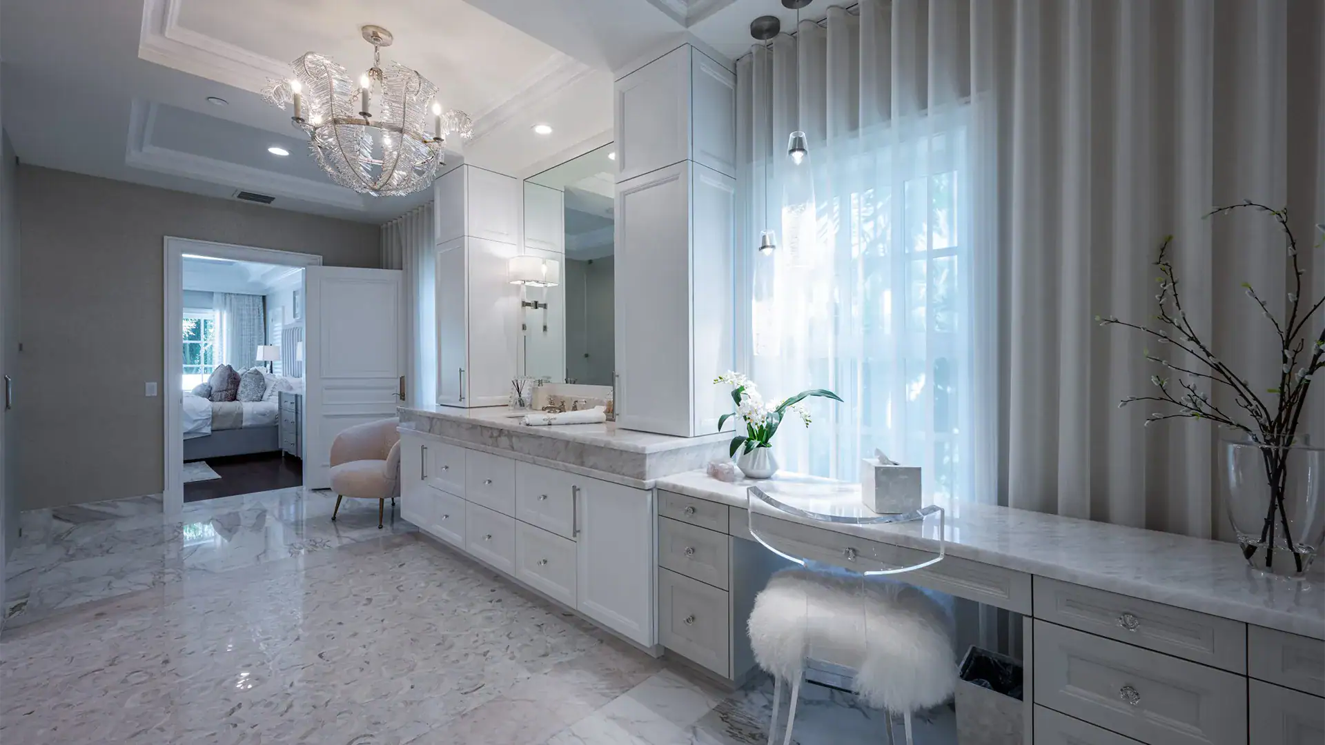 Stylish bathroom accentuated by Dolomite marble countertops and a lovely chandelier.