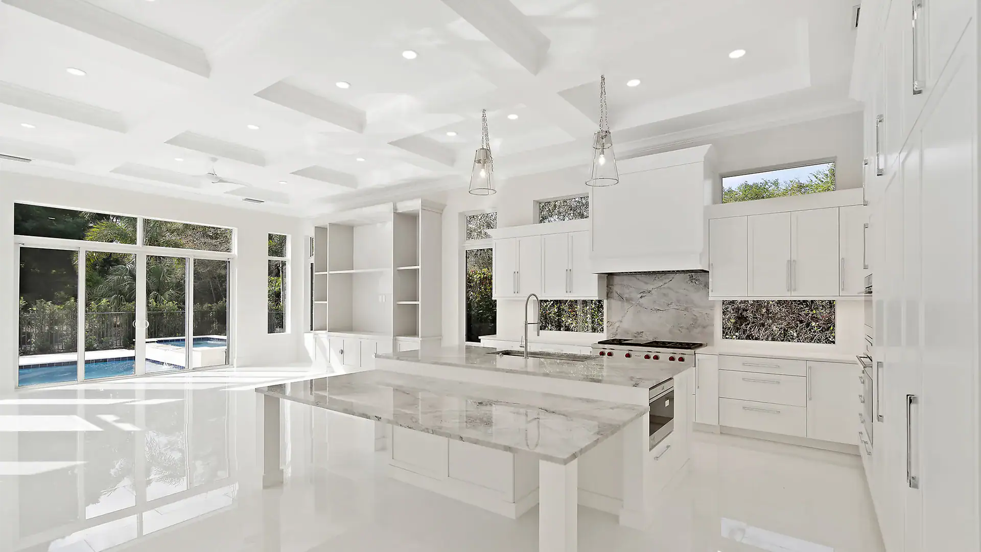 Large and airy kitchen with sleek white finishes and exquisite marble countertops.