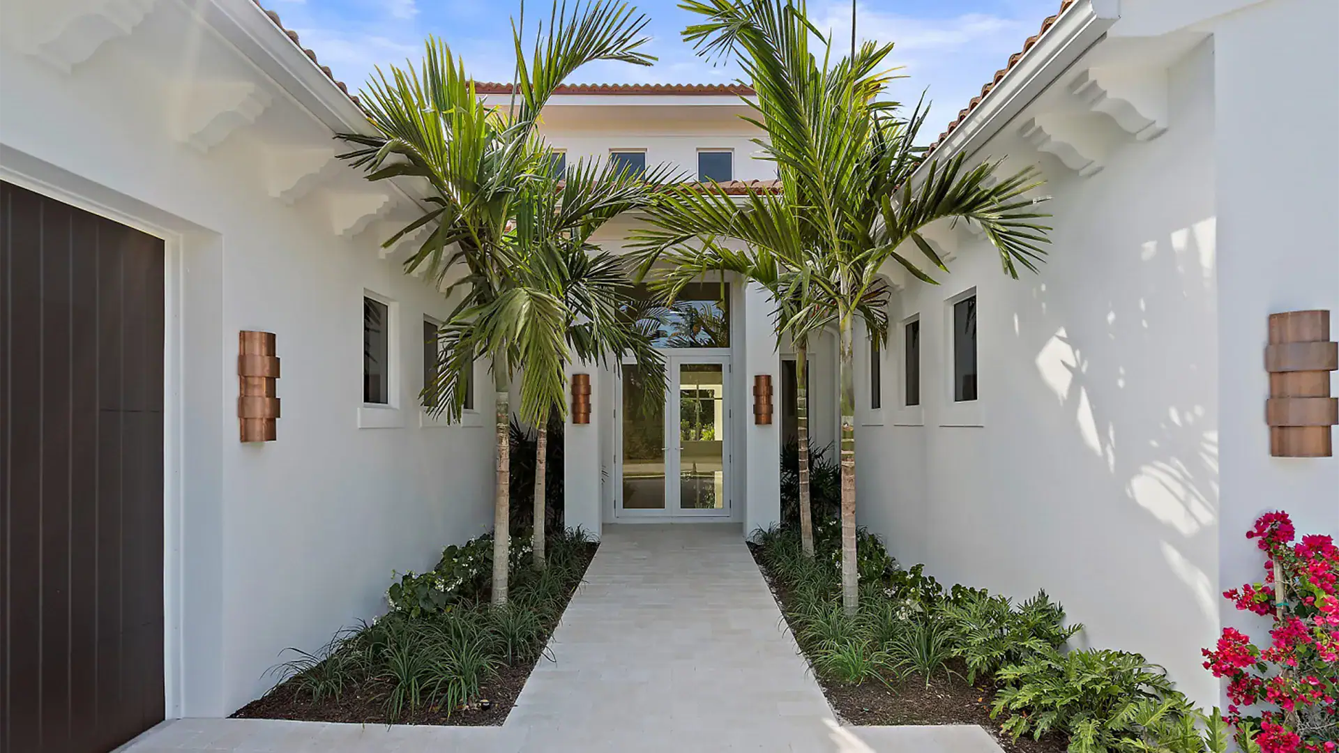 Beautiful pool adds to a Coastal Contemporary style modern home, with palm trees contributing to the peaceful, luxurious atmosphere.