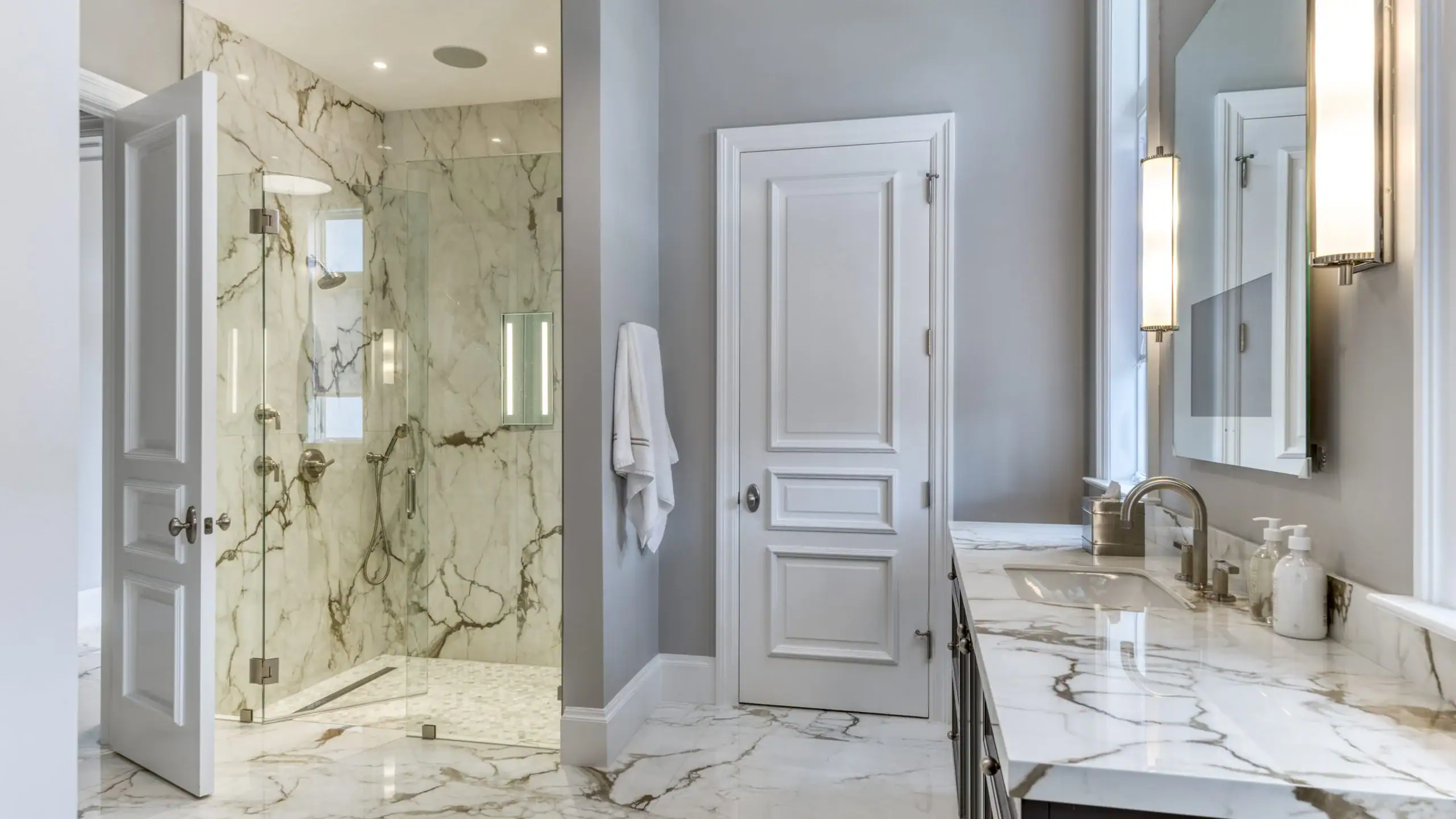 Bathroom featuring elegant marble flooring and pristine white walls.