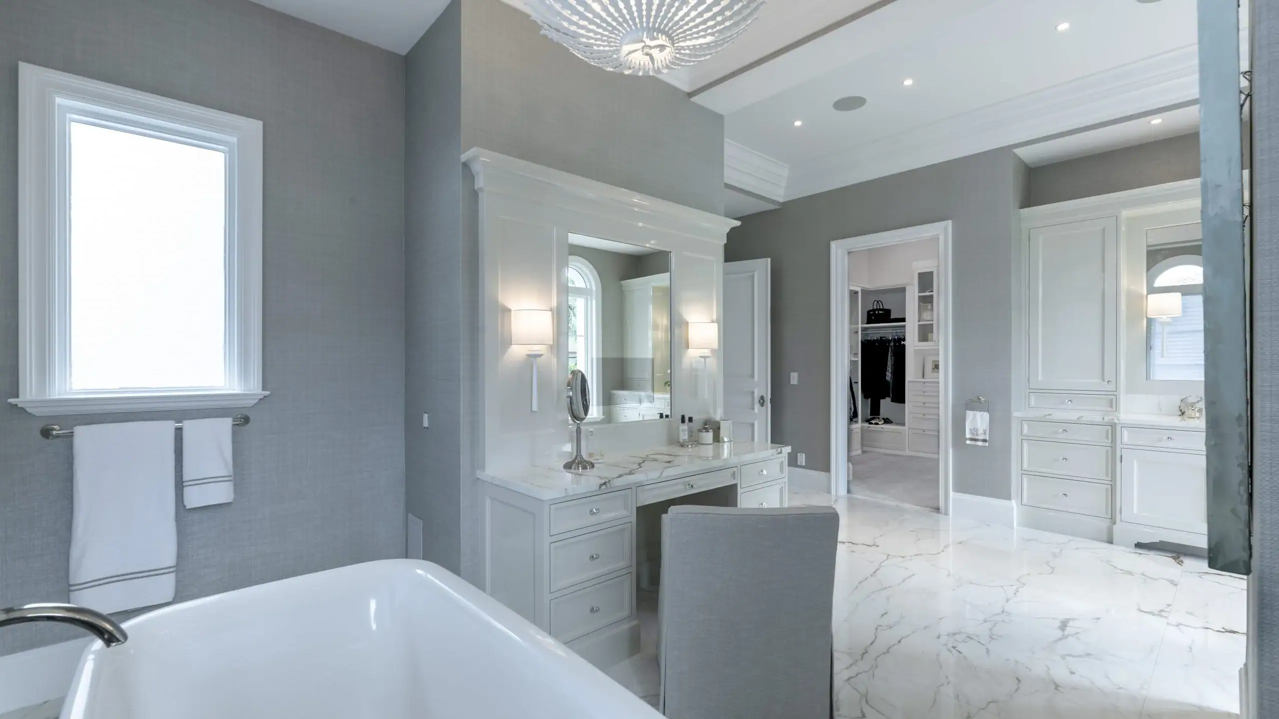 Bathroom featuring elegant marble floors and pristine white fixtures.