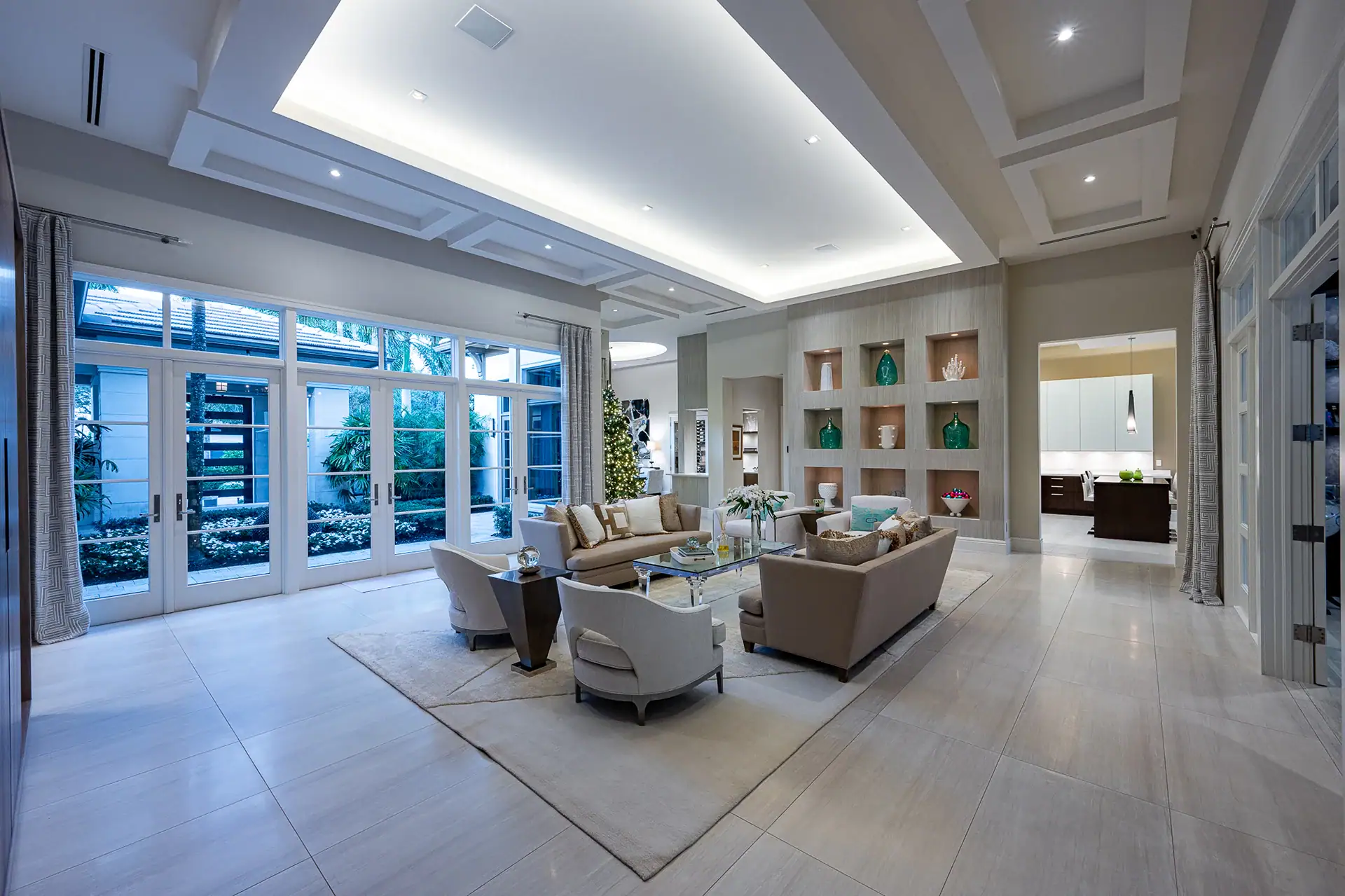 Expansive living room with white windows and wooden floors, highlighted by a stylish ceiling fan for a touch of luxury.