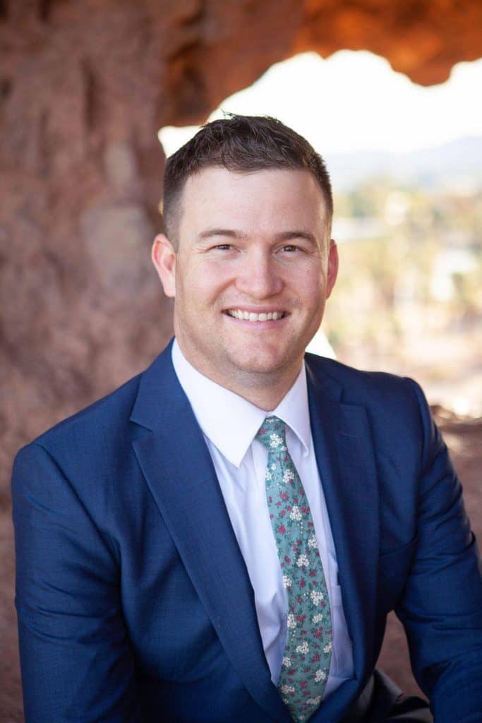 Professional lawyer in blue suit outdoors at Canyon State Law office.