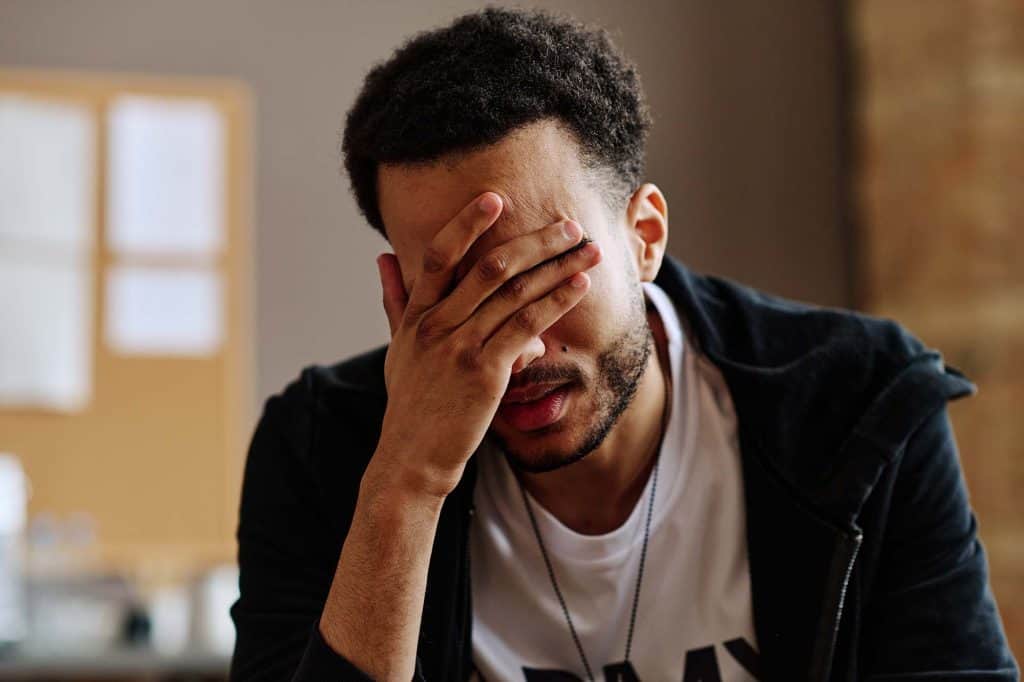 Stress and frustration in a young man experiencing emotional distress.