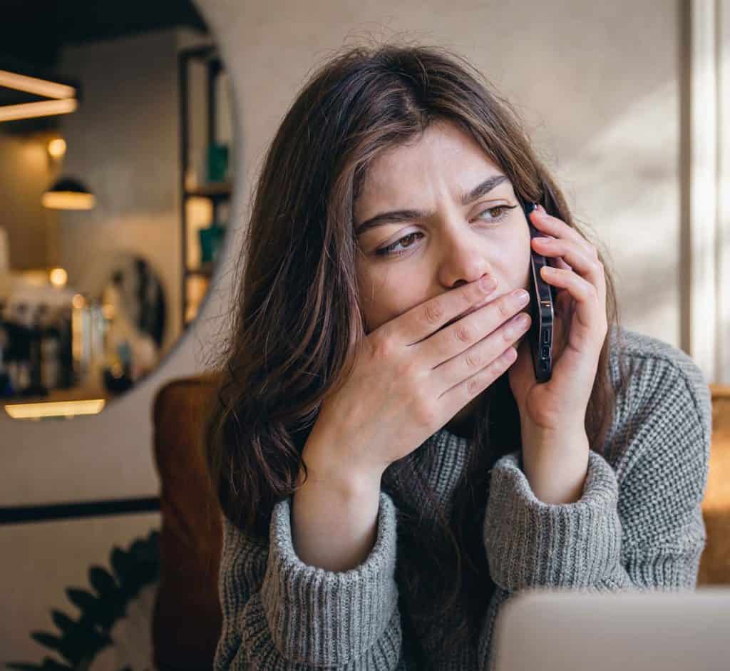 Woman on phone worried about legal issues, representing personal injury concerns.