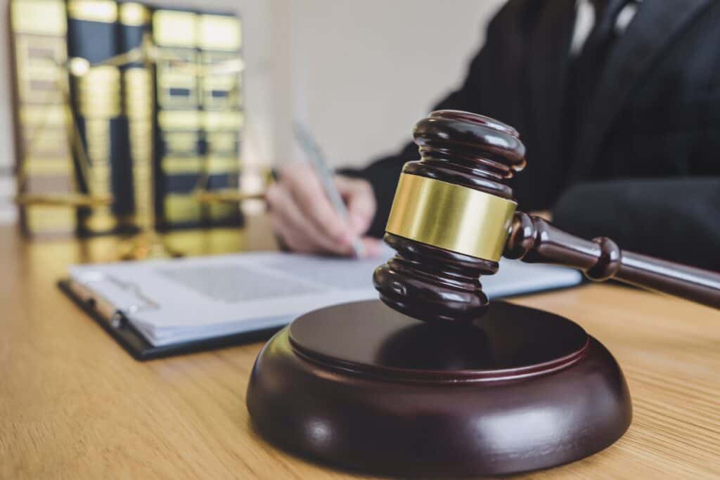 Gavel and legal documents on a wooden table in a law office setting.