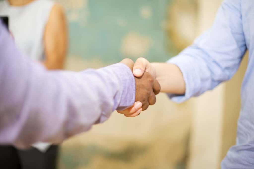Friendly handshake between two individuals representing legal agreement or partnership.