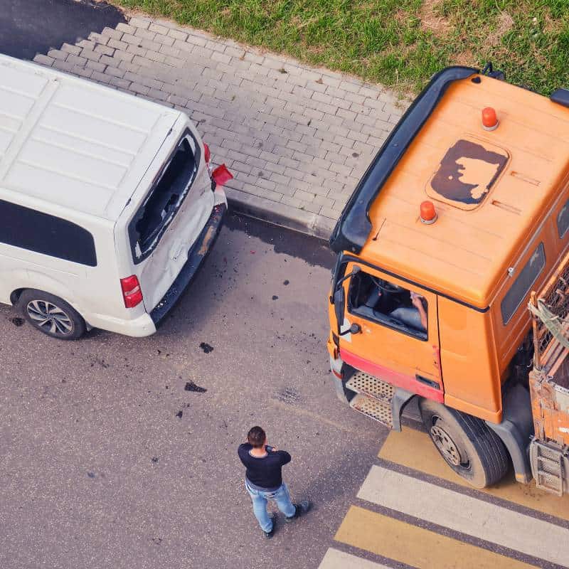 Accident scene with a white car and orange truck, highlighting the need for a local truck accident l.