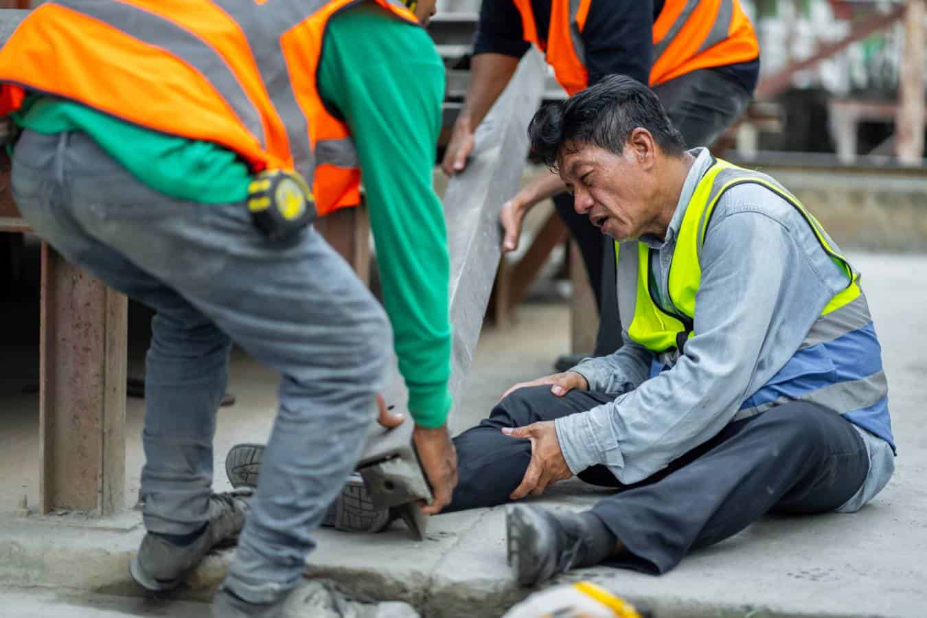 Injured construction worker receiving assistance after a fall or trip at a Mesa job site.