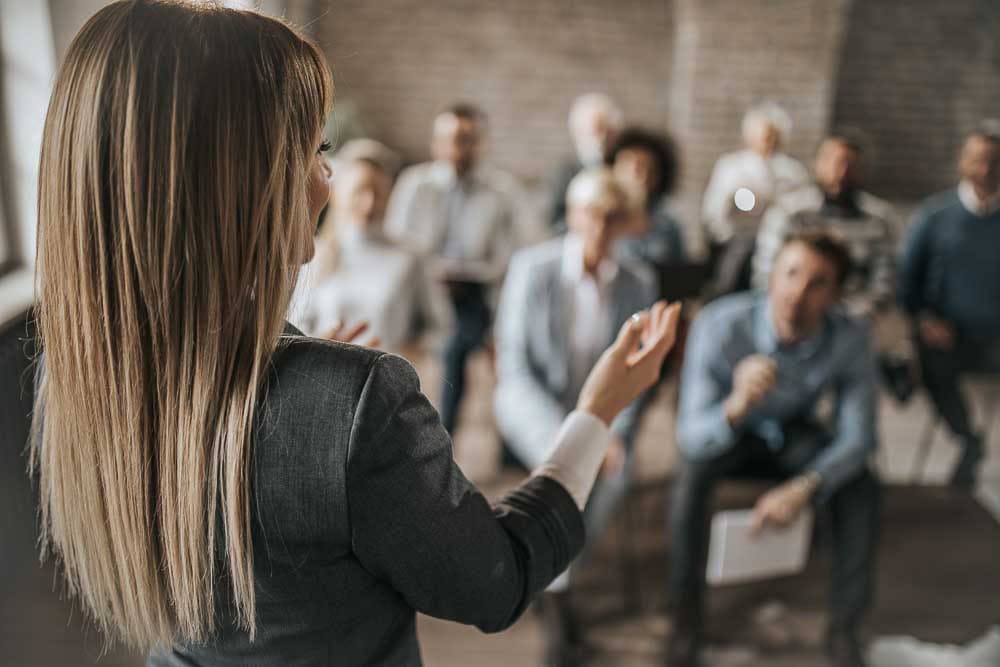 Leader addressing a seated group during a decision-making session.