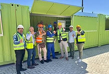 (from left to right) Leslie Jansen, Director Qabani National; Michael Gelderbloem, Director Zanmig; Edward Du Toit, Principle Agent - ACG Architects; Ndakuthini Tyitiko, Community Leader; Alderman James Vos, Mayoral Committee Member for Economic Growth; Leighroy Matthys, AED Project Manager and Councillor Kyle Carls, Subcouncil 2 chairperson. Inside the container Sitembele Nzayo, Site Supervisor Boshard Construction and Abduraghmaan Sayed, Site Supervisor Zanmig.