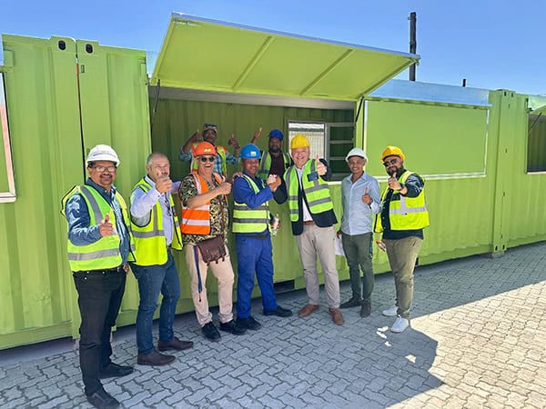 (from left to right) Leslie Jansen, Director Qabani National; Michael Gelderbloem, Director Zanmig; Edward Du Toit, Principle Agent - ACG Architects; Ndakuthini Tyitiko, Community Leader; Alderman James Vos, Mayoral Committee Member for Economic Growth; Leighroy Matthys, AED Project Manager and Councillor Kyle Carls, Subcouncil 2 chairperson. Inside the container Sitembele Nzayo, Site Supervisor Boshard Construction and Abduraghmaan Sayed, Site Supervisor Zanmig.