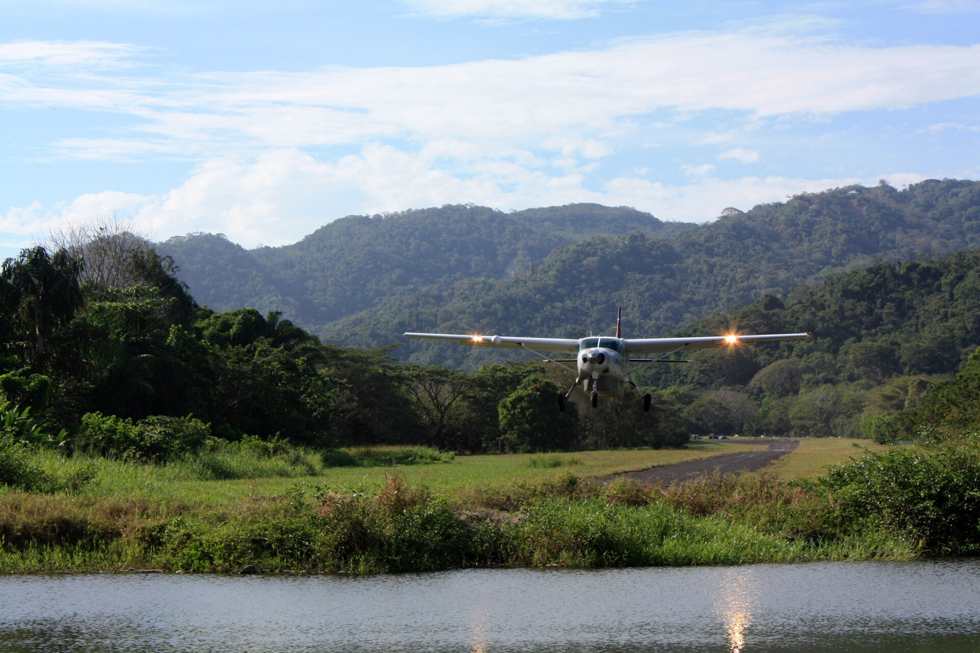 Small plane landing at Tambor airport, surrounded by jungle hills on the Nicoya Peninsula